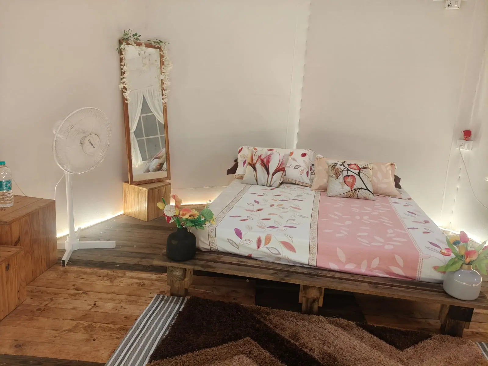 Cozy bedroom with floral bedding and wooden decor.